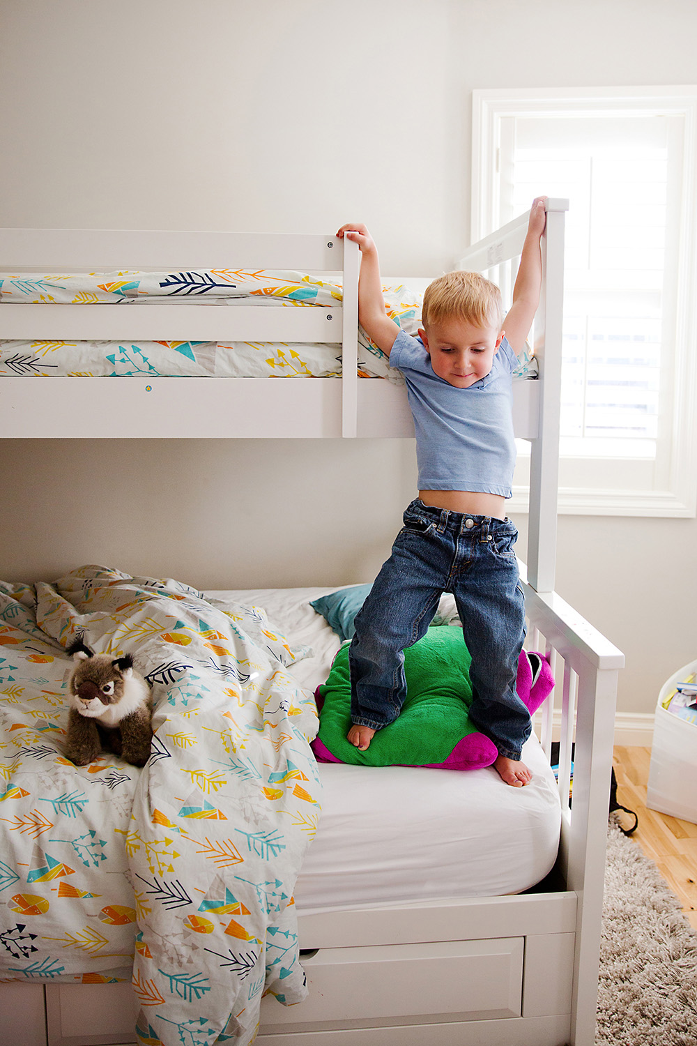 Boy awkwardly climbing down from the top bunk by Dana Pugh