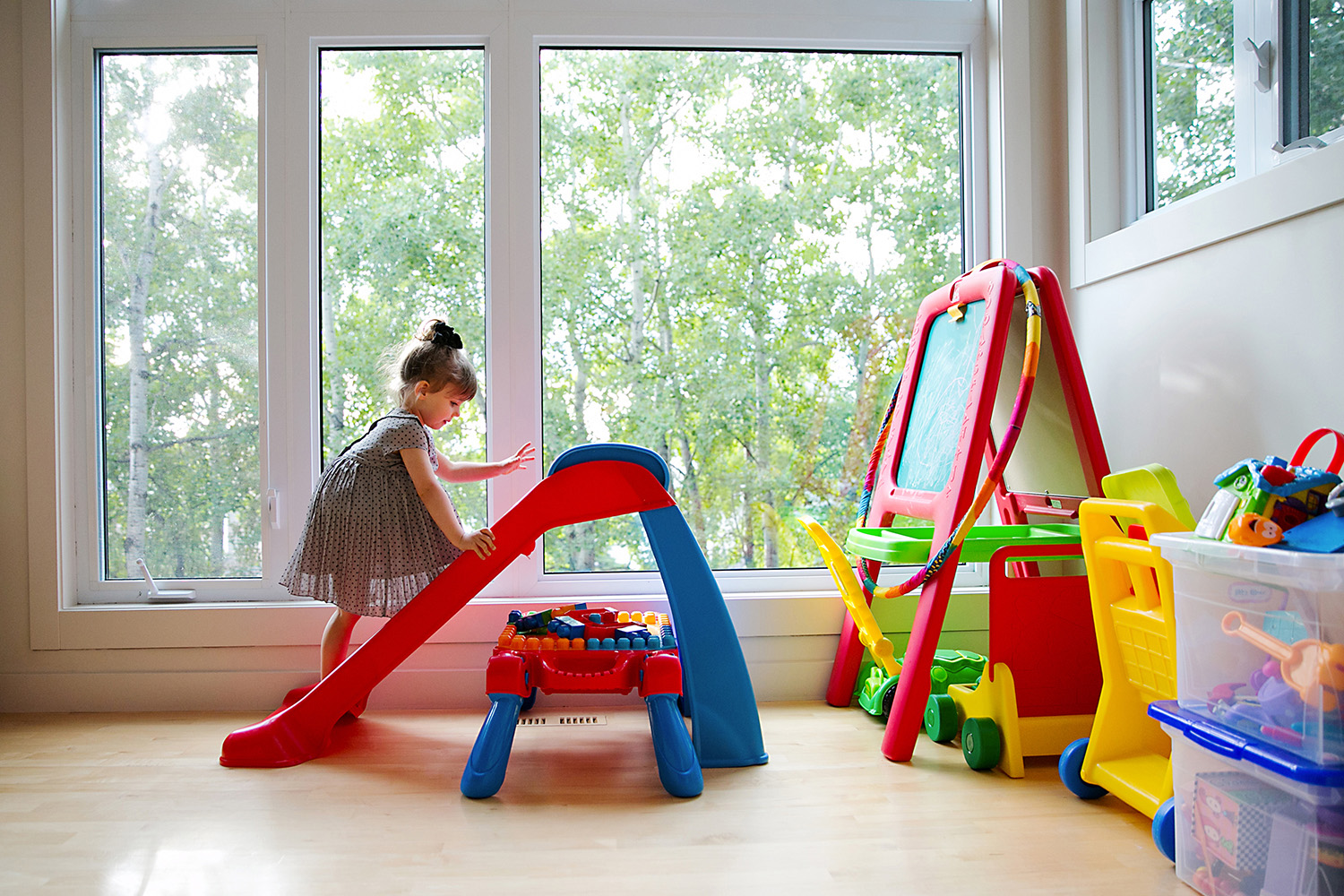 Toddler playing in her colorful playroom by Dana Pugh