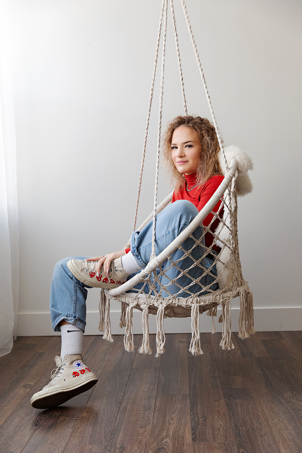 Converse wearing teenager on a crochet swing