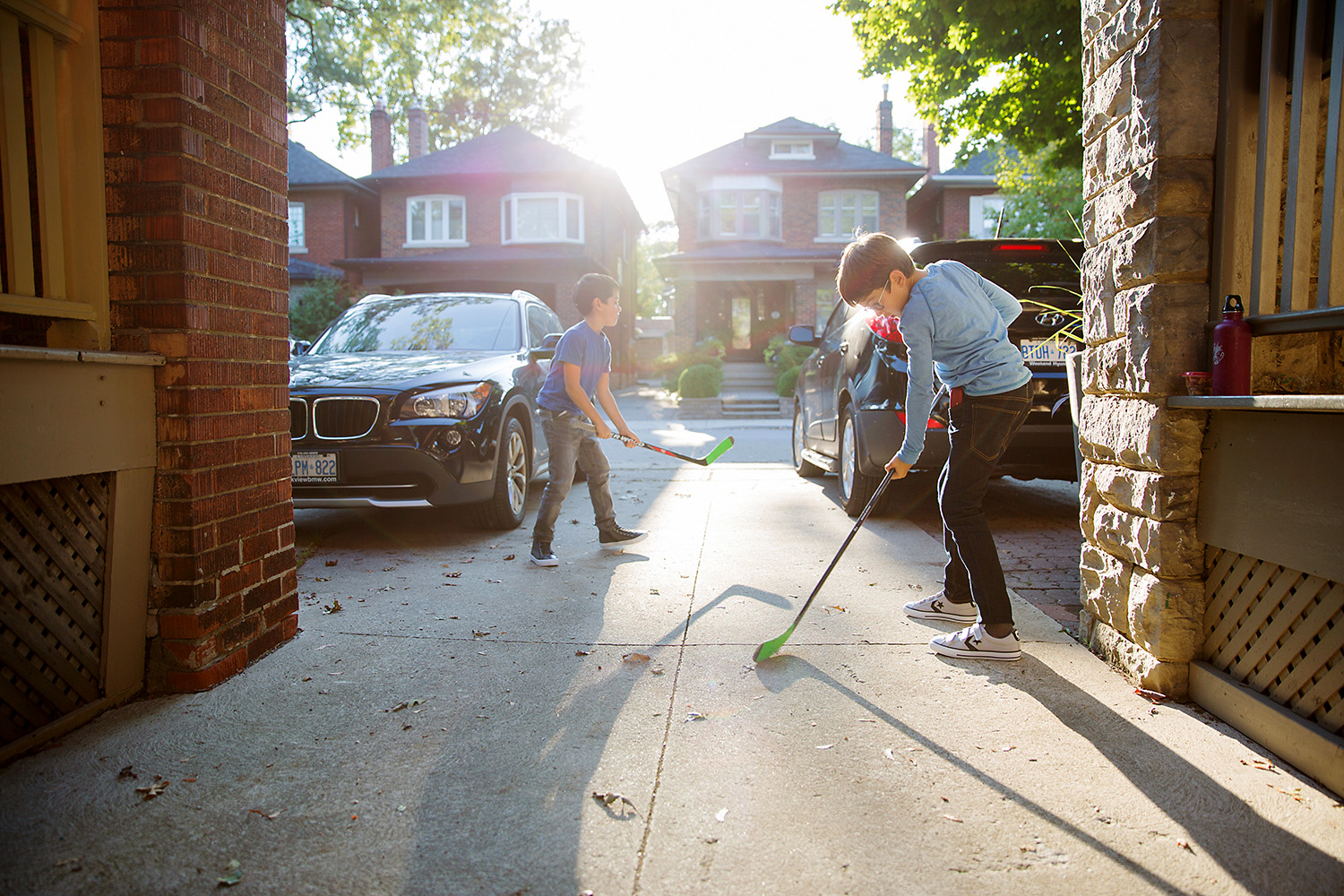 Brothers playing hockey in the front driveway in Toronto