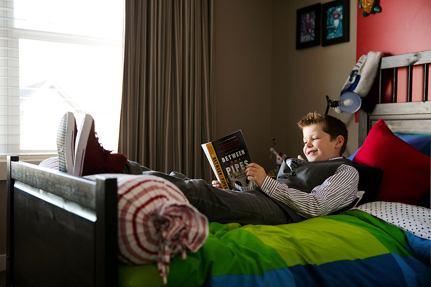 Teen boy reading a book in his bedroom 