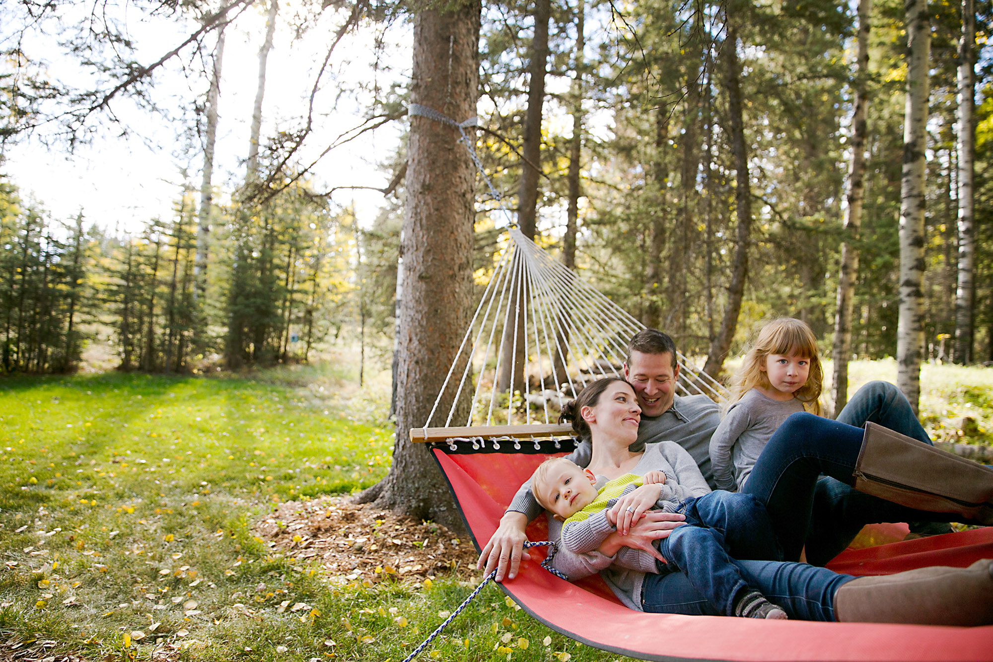 Family relaxing on their backyard hammock
