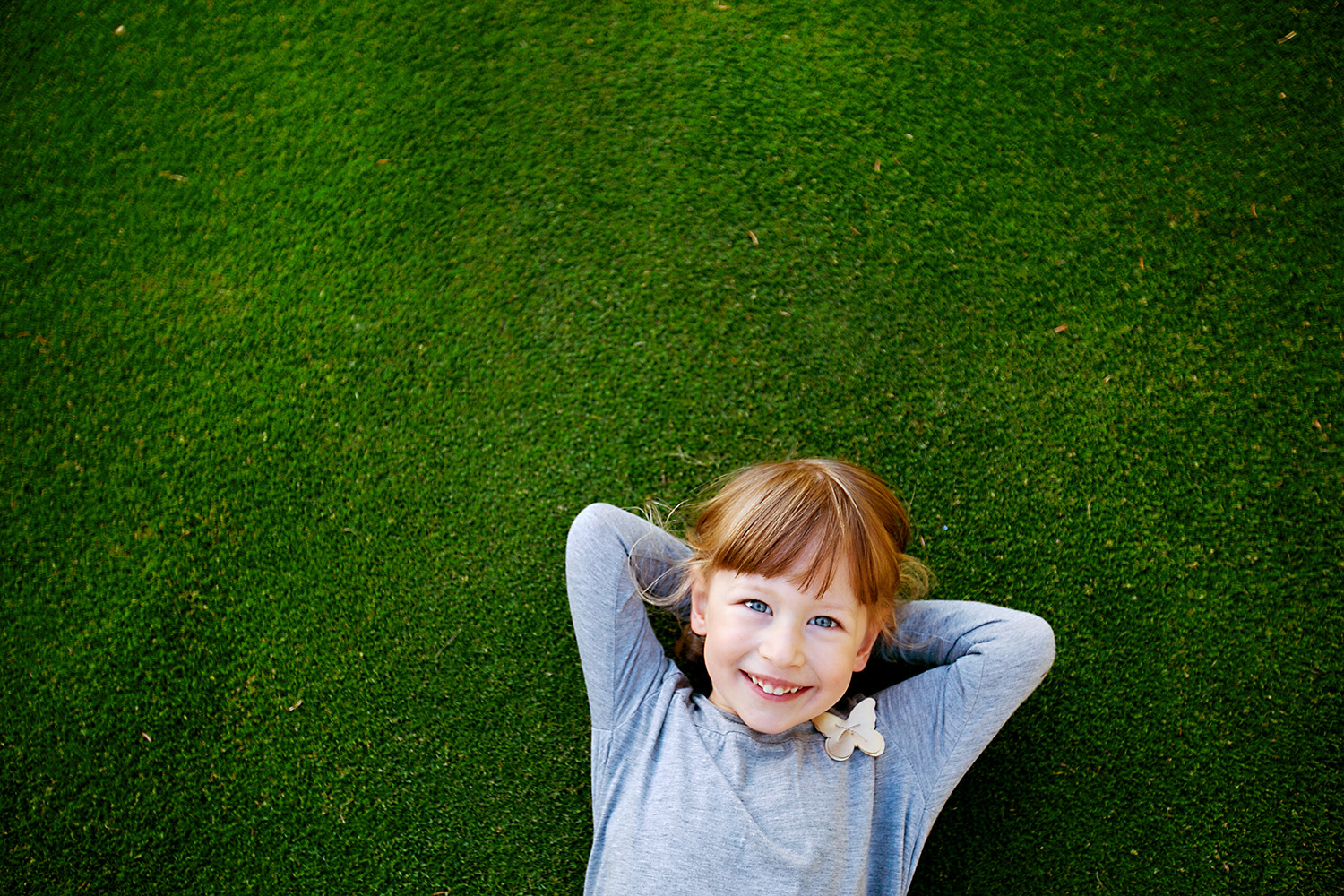 Daydreaming child laying in the grass