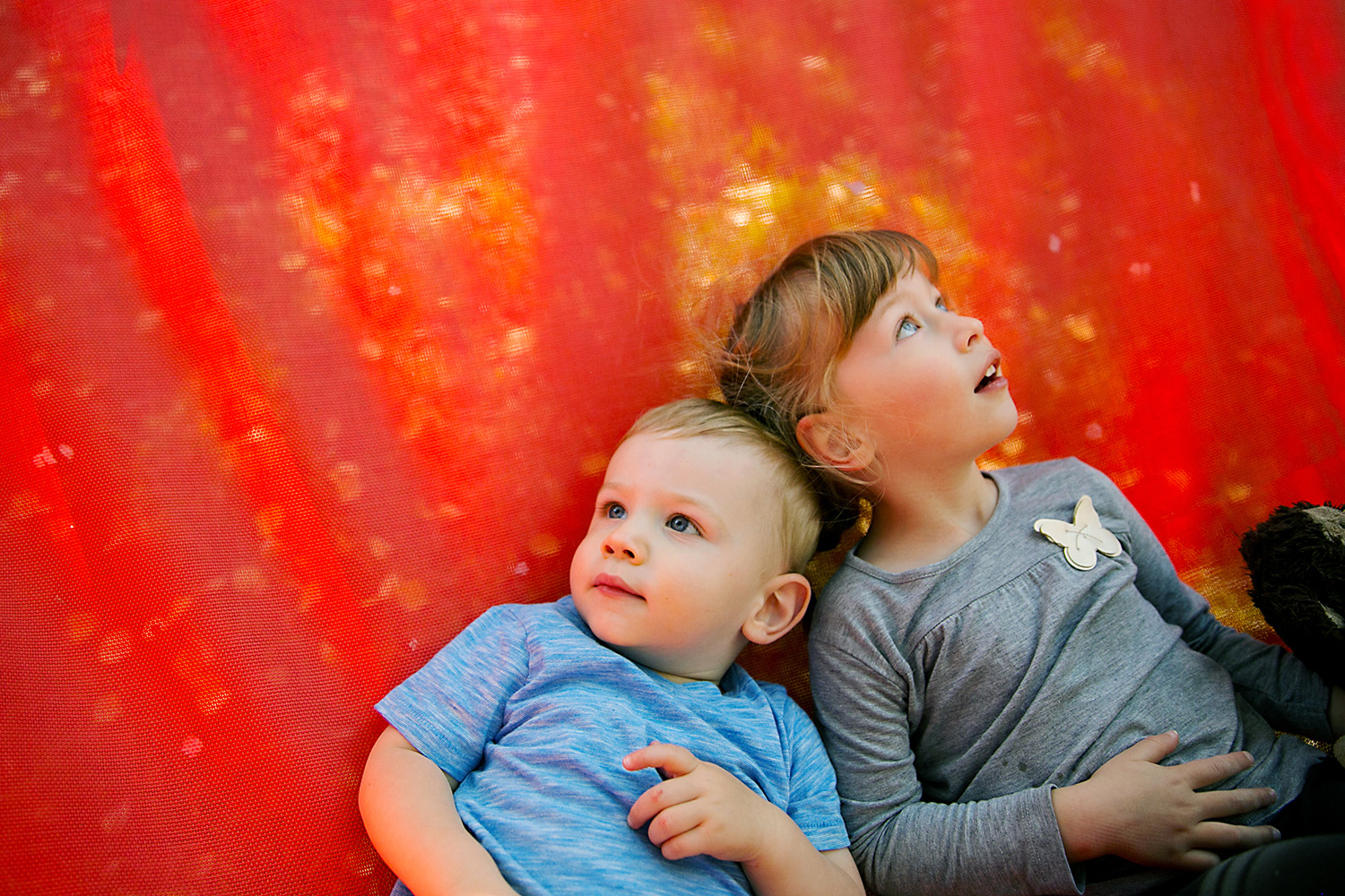 Siblings daydreaming on a hammock by Dana Pugh