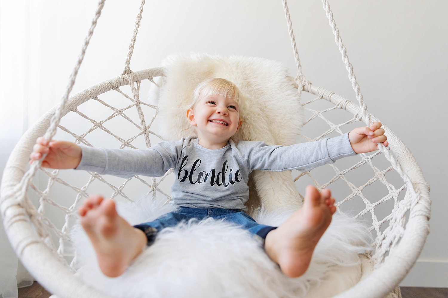 Happy child in a crochet chair by Dana Pugh
