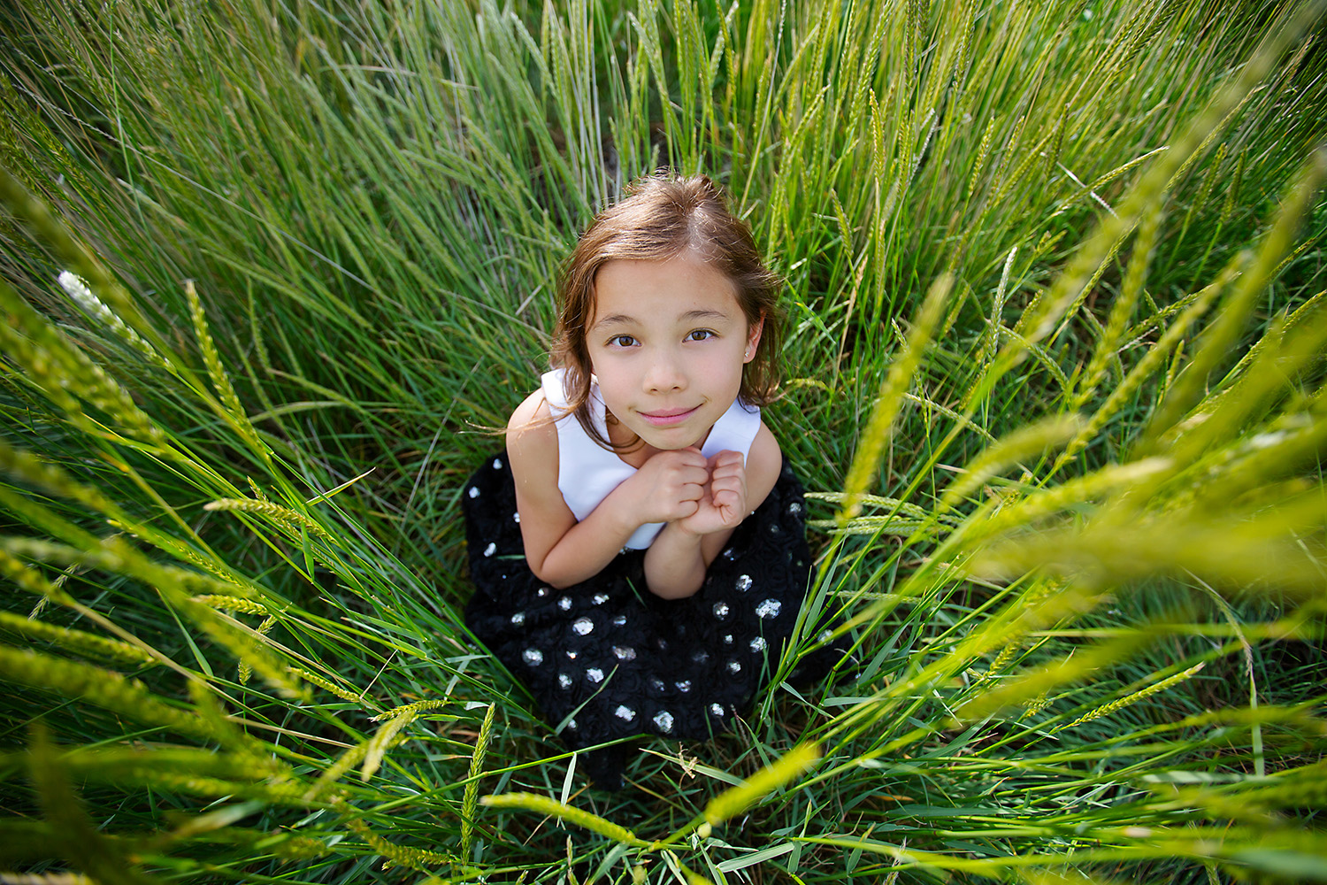 Girl hiding in the grass by Canadian Commercial photographer