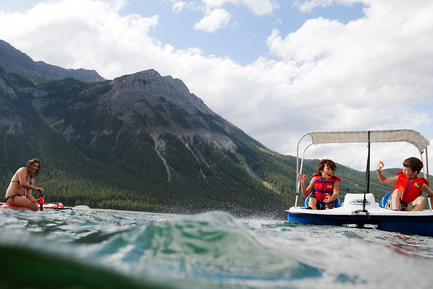 Children playing in a paddle boat in Kananaskis, Alberta