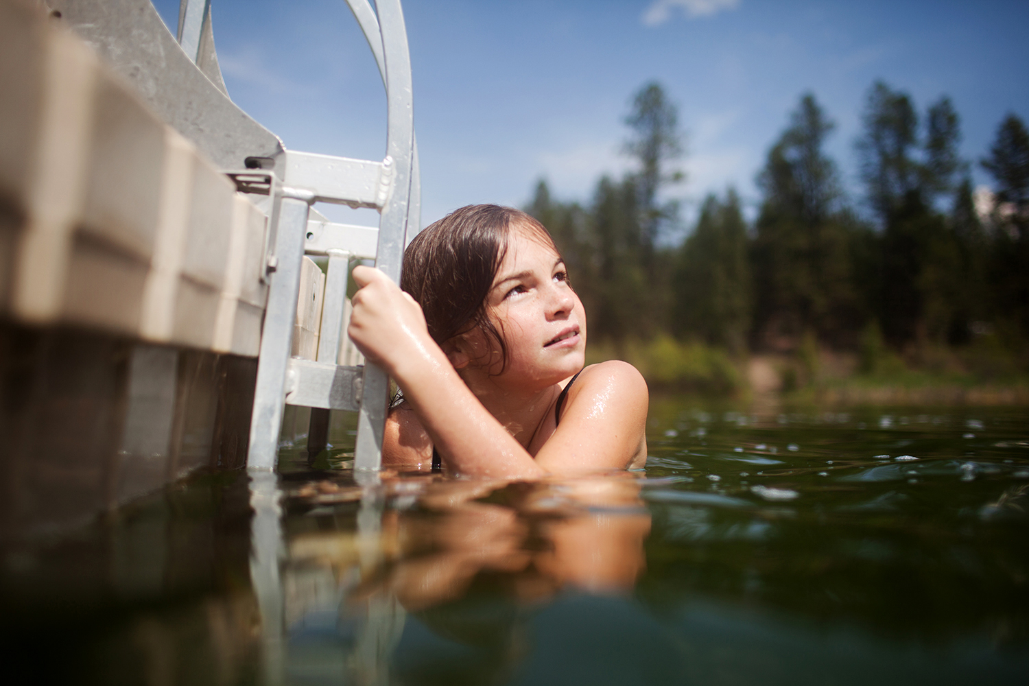 girl swimming to a floating deck in British Columbia
