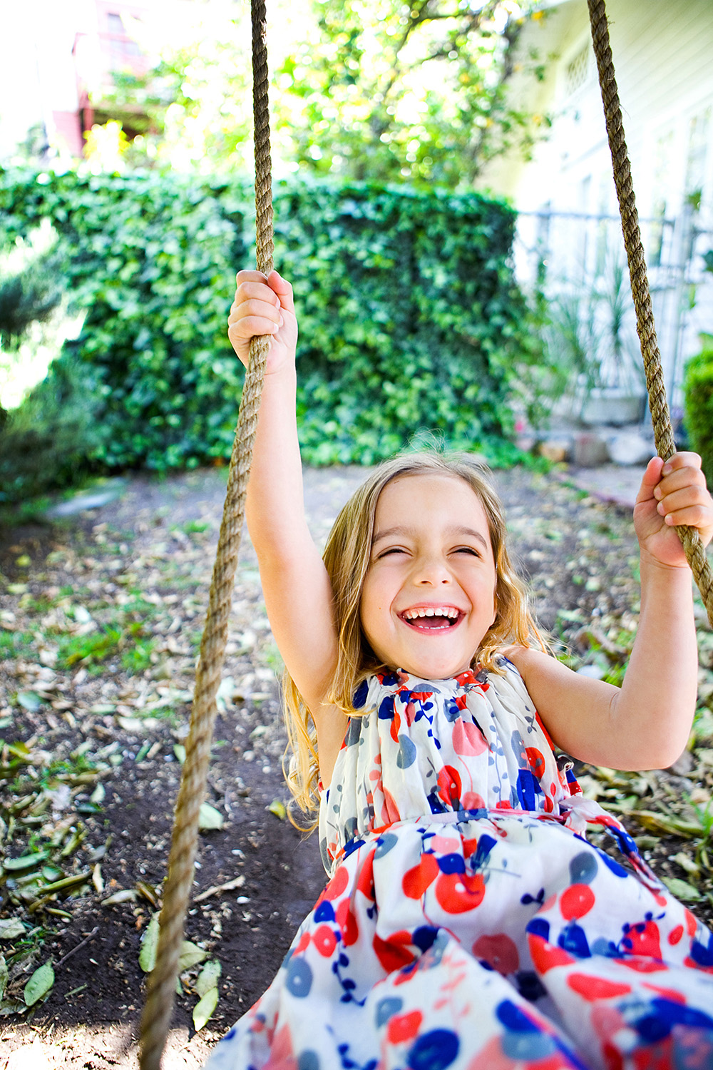 Girl on rope swing in her yard by Dana Pugh
