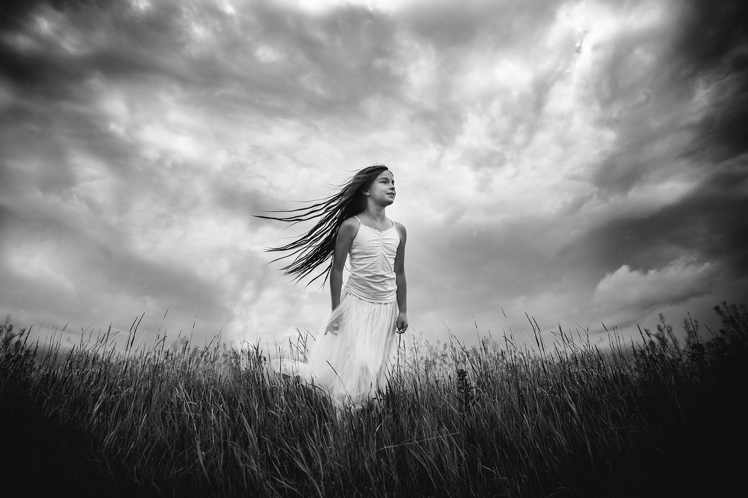 Lifestyle portrait of a girl against a stormy sky