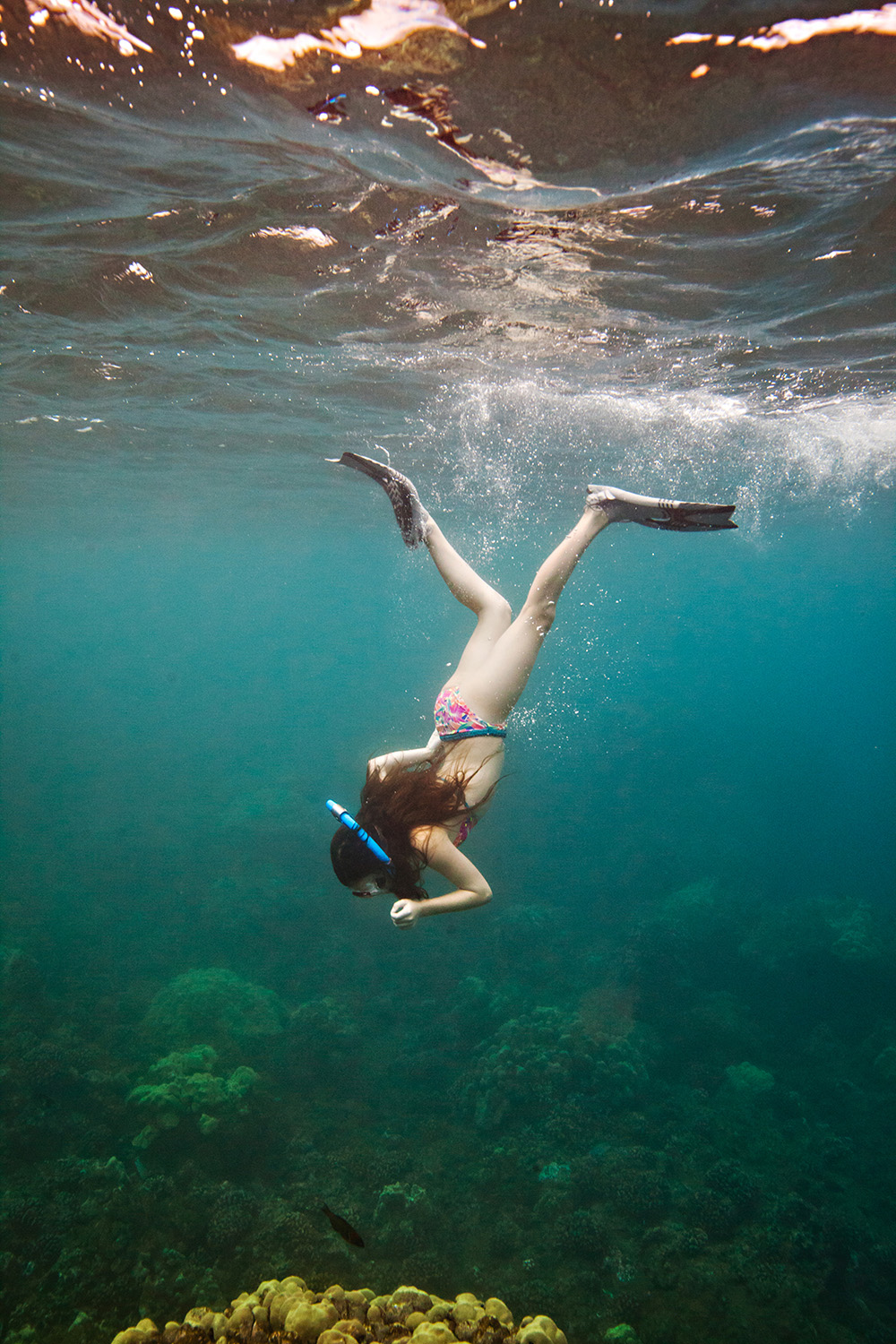 Child snorkelling underwater in Hawaii