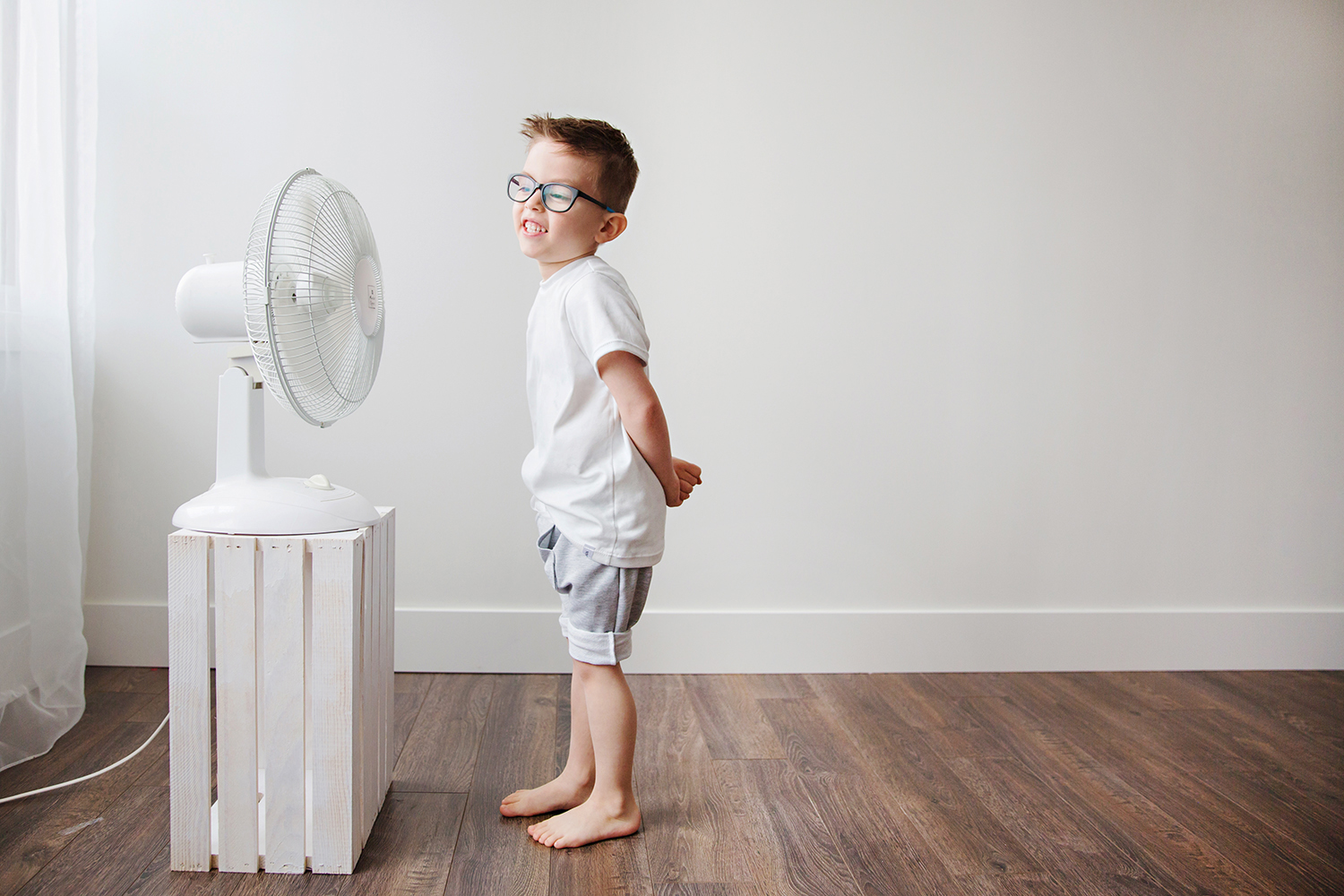 Studio fashion portrait of a boy in front of a fan